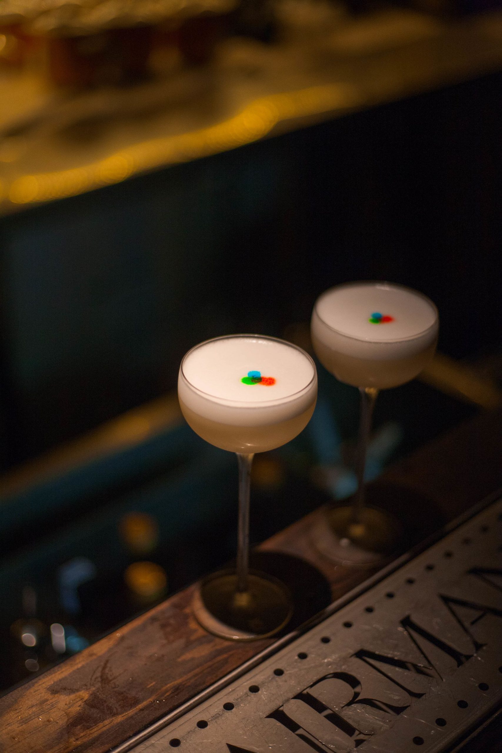 Two premium zero-proof cocktails on a dark bar